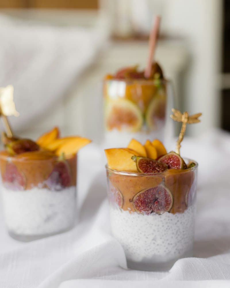 Small glasses of chia pudding topped with fruit and fresh figs